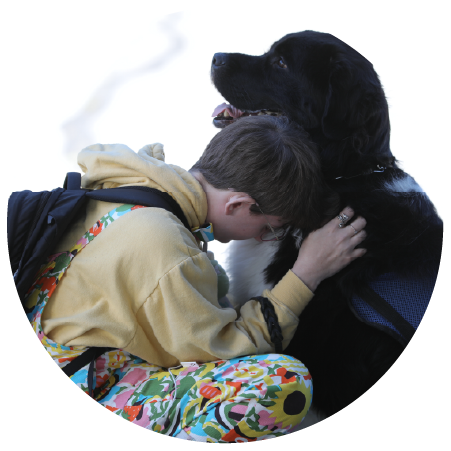 A young person hugging their service dog.